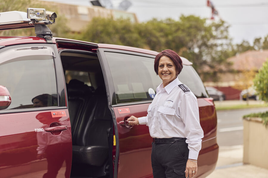 Female WAV driver standing next to open door