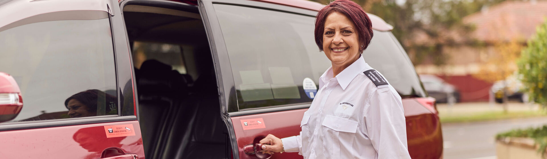 Female driver standing next to WAT holding door open