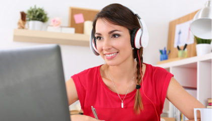 young woman on laptop wearing headphones