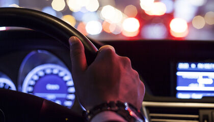 driver, night time, hand on wheel, lights, city, road