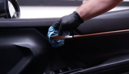 Hand cleaning car door interior with a wipe