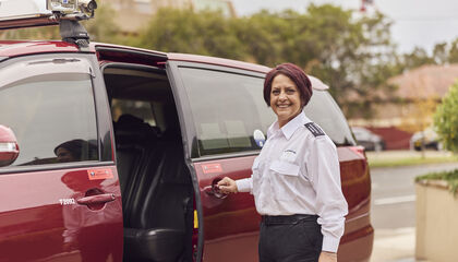 Female WAV driver standing next to open door