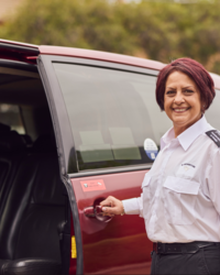 Image of female wheelchair accessible vehicle driver with open door